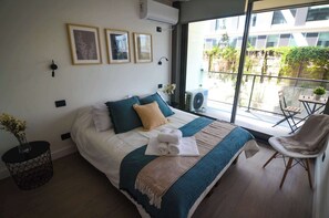 Relax in this cozy bedroom featuring a queen bed, stylish decor, and a private balcony perfect for morning coffee.