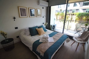 Relax in this cozy bedroom featuring a queen bed, stylish decor, and a private balcony perfect for morning coffee.