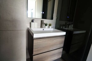 Experience a modern bathroom with sleek design and thoughtful touches, perfect for a refreshing retreat during your stay.