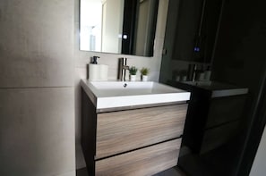 Experience a modern bathroom with sleek design and thoughtful touches, perfect for a refreshing retreat during your stay.