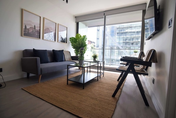 Bright and modern living room with large windows, stylish decor, and a cozy atmosphere, perfect for relaxation after a day of exploring.