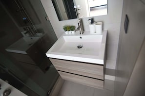 Experience modern comfort in this stylish bathroom featuring sleek design and minimalist decor for a refreshing stay.