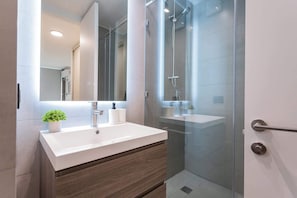 Experience a sleek and modern bathroom with stylish finishes and a refreshing ambiance for your relaxation.