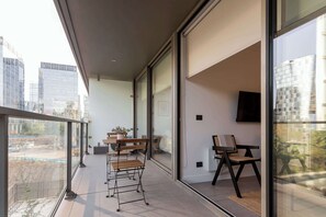 Enjoy a stylish urban retreat on this modern balcony, perfect for relaxing with city views and outdoor seating.