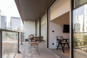Enjoy a stylish urban retreat on this modern balcony, perfect for relaxing with city views and outdoor seating.