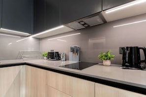 Experience culinary bliss in this modern kitchen, featuring sleek cabinetry and high-end appliances for your cooking adventures.