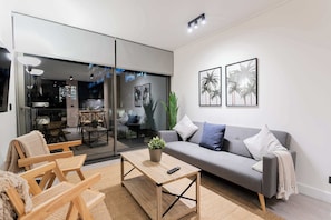 Chic city-view living room with cozy seating and modern decor, perfect for a relaxing urban getaway.