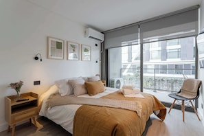 Experience comfort in this stylish bedroom with natural light, modern decor, and cozy touches for a relaxing stay.