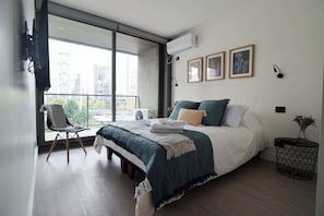 Chic urban retreat with stunning city views, modern decor, and cozy bedding for a perfect getaway.