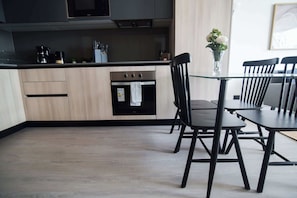 Experience modern living in this sleek kitchen, featuring stylish cabinetry and a cozy dining area perfect for meals and gatherings.