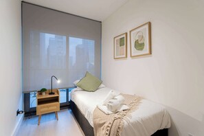 Cozy bedroom with modern decor and city views, perfect for a restful stay in the heart of the city.