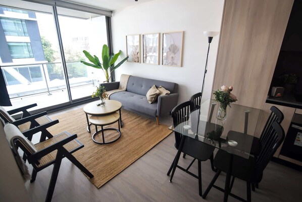 Bright and modern living space with large windows, stylish furnishings, and a cozy atmosphere—perfect for relaxation during your getaway!
