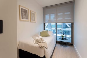 Cozy single bedroom with a serene view and modern decor, perfect for a restful stay in the heart of the city.