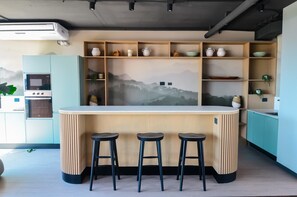 Experience culinary bliss in this modern kitchen, featuring sleek design and a stunning mountain mural backdrop.