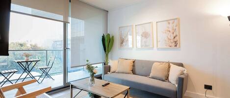Bright and modern living room with a cozy balcony, perfect for relaxing and enjoying the view.