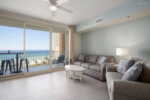Open concept living area with sleeper sofa TV and balcony access
