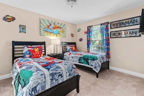 Our Marvel-themed bedroom features comfortable twin beds, superhero bedding, and vibrant artwork.