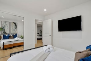 Style, comfort, and functionality all in one ✨ This bedroom features a sleek TV, a stylish cabinet with sliding doors, and a full-length mirror for the perfect finishing touch.