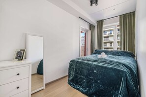 Comfortable bedroom with a large bed and city views.