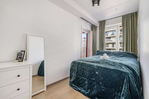 Comfortable bedroom with a large bed and city views.