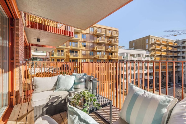 Sunny balcony with comfortable seating, perfect for relaxing.