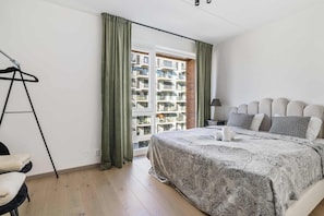 Spacious bedroom with a view of the city.