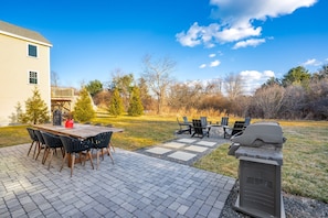 Spacious back yard with outdoor seating, grill, and fire pit area