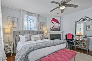 Step into our glam room, where a plush queen bed, sleek TV, and bold fuchsia accents combine to create a chic, unforgettable retreat.