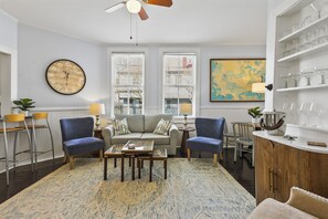 Relax in comfort and style in the cozy living room, where modern furnishings blend seamlessly with historic charm for the perfect place to unwind.