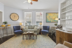 Relax in comfort and style in the cozy living room, where modern furnishings blend seamlessly with historic charm for the perfect place to unwind.