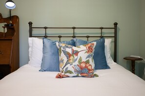 Drift into comfort on the cozy queen bed—complete with extra pillows and a soft blanket for a restful night’s sleep.