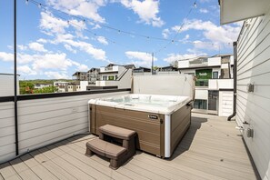 Private rooftop deck with hot tub, outdoor seating, bistro lighting, and stunning city skyline views. (4th Floor)