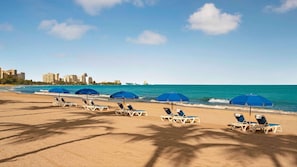 On the beach, white sand, sun loungers, beach umbrellas