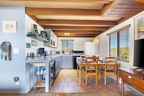 Enjoy home-cooked meals and morning coffee in this bright, fully equipped kitchen and dining space—framed by forest views and cozy cabin charm. ☕🍽️🌲