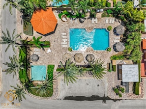 Tropical resort setting with multiple pools, palapas, and lush greenery.