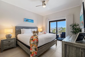 King bedroom with balcony access, Smart TV, and calming coastal décor.