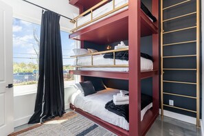 Unit 2: 4th Bedroom with a custom triple Full Bunk-Bed, Smart TV, LED Vanity w/ stool, and an en-suite bathroom. (1st Floor)