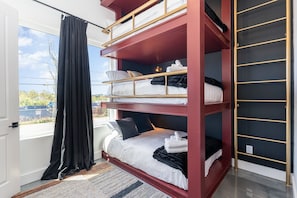 Unit 2: 4th Bedroom with a custom triple Full Bunk-Bed, Smart TV, LED Vanity w/ stool, and an en-suite bathroom. (1st Floor)