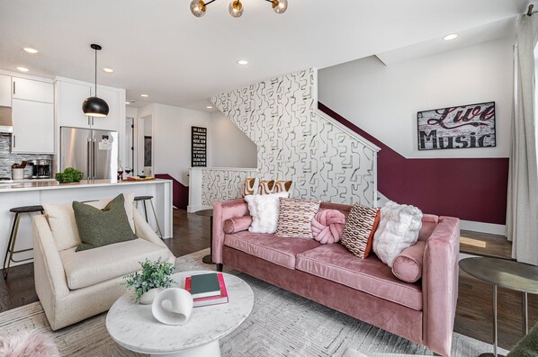 Unit 1: Open-floor living space featuring a smart TV and designer furnishings. (2nd Floor)