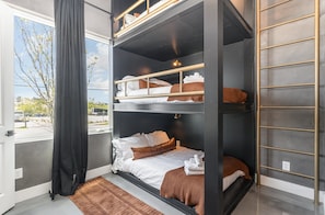 Unit 1 (1st Floor): 4th Bedroom featuring a Bunk Bed with 3 Full beds, Get Ready Vanity, Smart TV, and en-suite bathroom.