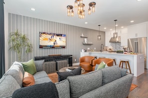 Unit 1 (2nd Floor): Open-floor living space featuring a Smart TV and designer furnishings.