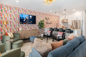 Unit 2 (2nd Floor): Bright and colorful open-concept living area featuring a Smart TV and stylish furnishings.