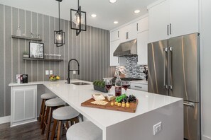 Unit 1 (2nd Floor): Fully equipped kitchen with stainless steel appliances and a kitchen island with seating for 4 guests.