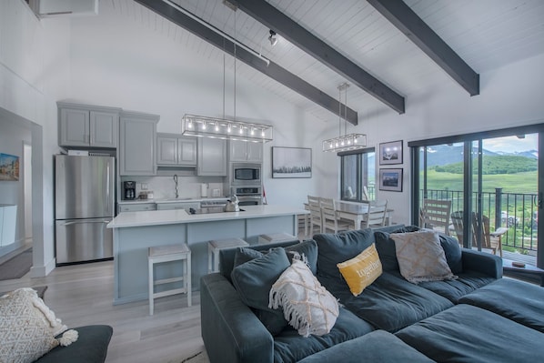 Expansive great room & kitchen with triple sliding glass doors for all day views