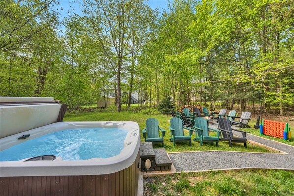 Soak in the serenity—enjoy a relaxing evening in the private hot tub while the sun sets behind the trees, creating a peaceful backdrop for couples or the whole family.