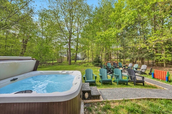 Soak in the serenity—enjoy a relaxing evening in the private hot tub while the sun sets behind the trees, creating a peaceful backdrop for couples or the whole family.