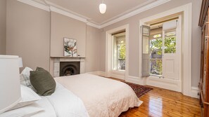 Bedroom one with balcony access and ornamental fireplace 