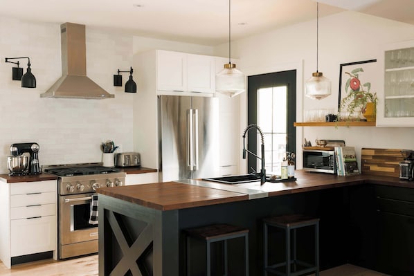 Welcome to Squirrel Haus. Fully equipped kitchen, open concept to dining + living room area.