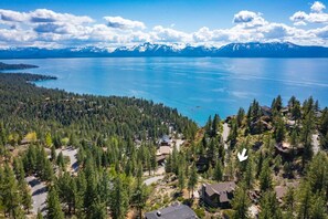 Bird’s-eye view of the home nestled in the hillside, moments from the shoreline
