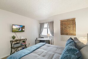A cozy bedroom with flat-screen television